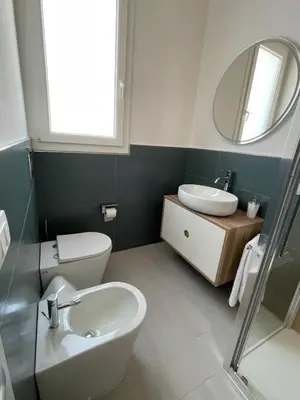 a bathroom with a sink and a toilet and a mirror at Martanna Rooms in Carini