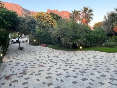 a stone driveway with trees and mountains in the background at La Casa di Dada in Terrasini
