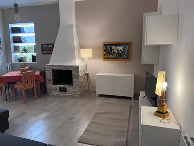 a living room with a fireplace and a dining room at La Casa di Dada in Terrasini