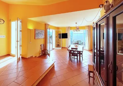 a living room with yellow walls and a table and chairs at Solemar Sicilia - Villa Elis in Bagheria