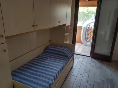 a bed in a room with a sliding glass door at Casa Vacanze Villa Pomelia in Campofelice di Roccella