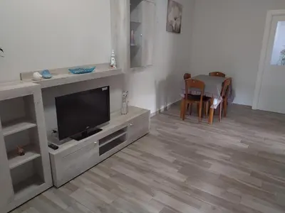 a living room with a television and a table at Casa Vacanze Villa Pomelia in Campofelice di Roccella