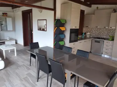 a kitchen with a long table and chairs at Casa Vacanze Villa Pomelia in Campofelice di Roccella