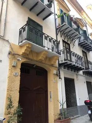 a building with a brown door and a balcony at A casa di Simona in Palermo