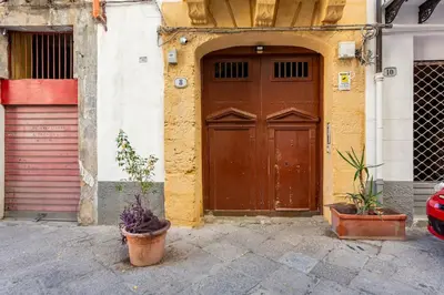 a building with a brown door and some plants in front at A casa di Simona in Palermo