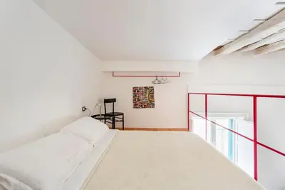 a white bedroom with a bed and a window at A casa di Simona in Palermo