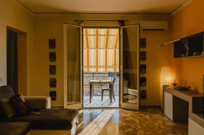 a living room with a door open to a balcony at Casa Vacanza Stella Maris in Isola delle Femmine