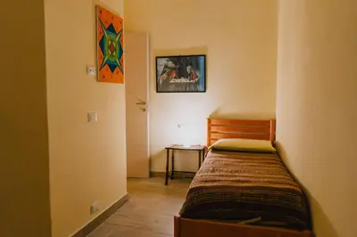 a small bedroom with a bed and a table at Casa Vacanza Stella Maris in Isola delle Femmine