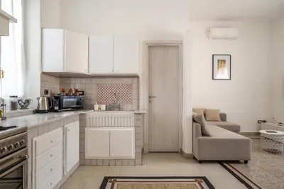 a kitchen with white cabinets and a couch in a room at [La Maiolica] - Centro storico in Palermo