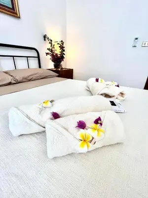 two beds with white towels and flowers on them at Sunny Home in Palermo