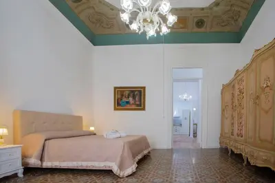 a bedroom with two beds and a chandelier at Terre d'oro, appartamento di lusso in centro città in Palermo