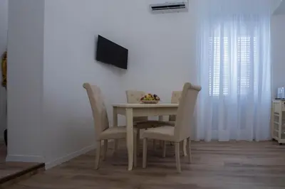 a dining room table with chairs and a television on a wall at Terre d'oro, appartamento di lusso in centro città in Palermo