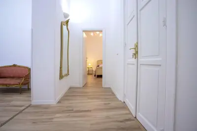 a hallway with white walls and wood floors and a mirror at Terre d'oro, appartamento di lusso in centro città in Palermo