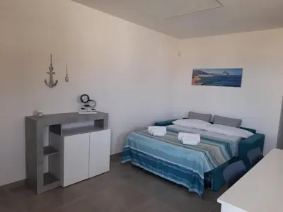 a small bedroom with a bed and a sink at Casa vacanze I colori del mare in Alcamo Marina