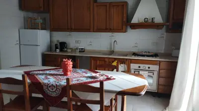 a kitchen with a table with chairs and a stove at La casa di Nanà in centro in Palermo