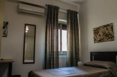 a bedroom with a bed and a mirror and a window at Alexander House in Palermo