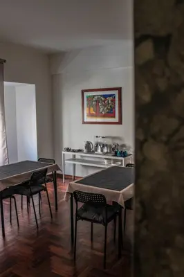a room with two tables and chairs and a kitchen at Alexander House in Palermo