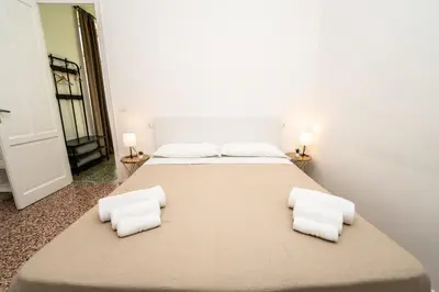 a large bed with white sheets and pillows in a room at Valguarnera Studio Apartments in Palermo