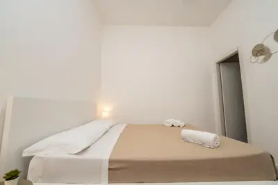 a white bedroom with a bed with towels on it at Valguarnera Studio Apartments in Palermo