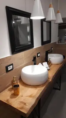 a bathroom with a large white sink and two mirrors at Garden Suite Apartment in Palermo