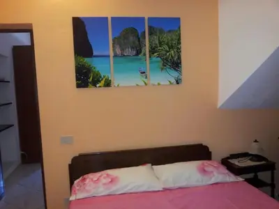 a bedroom with a bed with two paintings on the wall at Casa Vacanza Terrazza sul Mare in Castellammare del Golfo