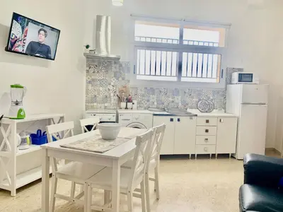 a kitchen with a white table and a white refrigerator at Finestra sul Mare di Alessandro in Balestrate