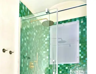 a shower with a glass door and green tiles at Casa 900 in Castellammare del Golfo