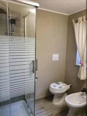 a bathroom with a shower and a toilet and a sink at Ally's house in Palermo