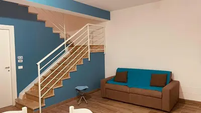 a living room with a staircase and a couch at L'angolo in centro in Partinico