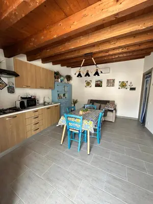 a kitchen and dining room with a table and chairs at PortAzzurra in Carini
