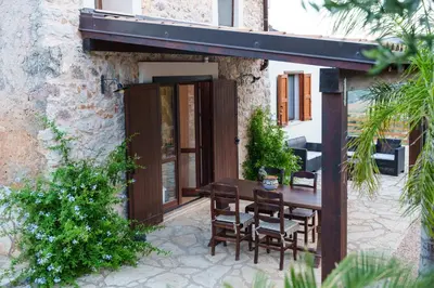 a patio with a table and chairs outside of a building at Al ficodindia in Scopello