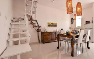 a dining room with a wooden table and a ladder at Amazing Home In Trappeto With Wifi in Trappeto