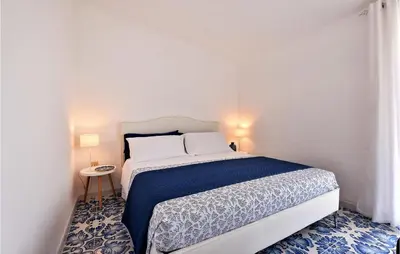 a bedroom with a bed with a blue and white bedspread at Amazing Home In Trappeto With Wifi in Trappeto