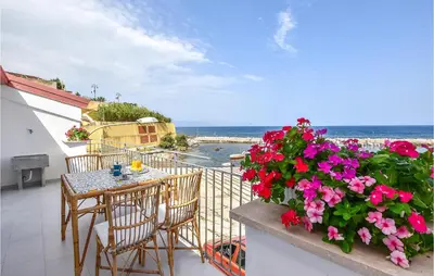 a balcony with a table and chairs and flowers at Amazing Home In Trappeto With Wifi in Trappeto