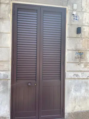 a wooden door on the side of a stone building at Casa vacanze Soraja in Palermo