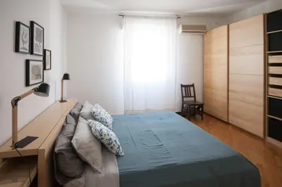 a bedroom with a bed and a desk and a window at Casa Sul Mare Seaside apt in front of the sea in Palermo