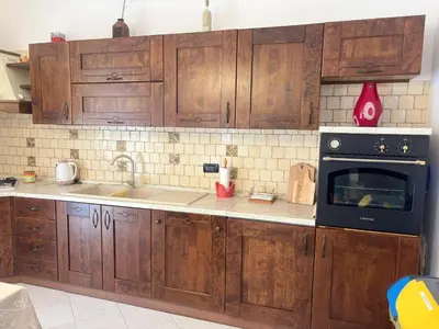 a kitchen with wooden cabinets and a black oven at Casa Vacanze Gloria in Balestrate