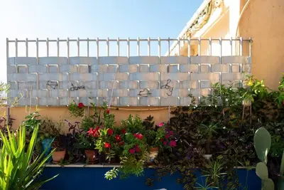 a retaining wall with a bunch of flowers and plants at Bella Vista Sant Orsula 2 bedroom View Terrace Historic Center Spacious Apartment in Termini Imerese