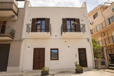 a white house with two balconies and two windows at La Chiostrina 2 in Castellammare del Golfo
