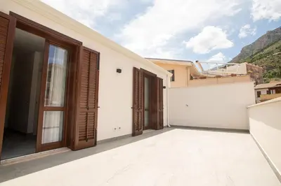a balcony of a house with wooden doors at La Chiostrina 2 in Castellammare del Golfo