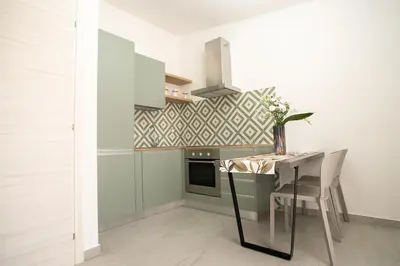 a kitchen with a table and chairs and a stove at La Chiostrina 2 in Castellammare del Golfo