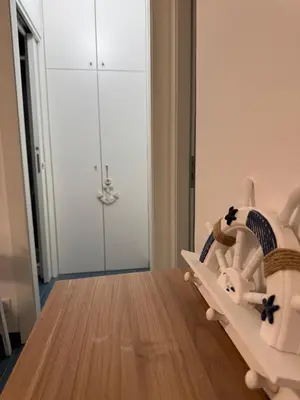 a white crib in a room with a wooden floor at Casa Vacanze Marinella Beach in San Vito lo Capo