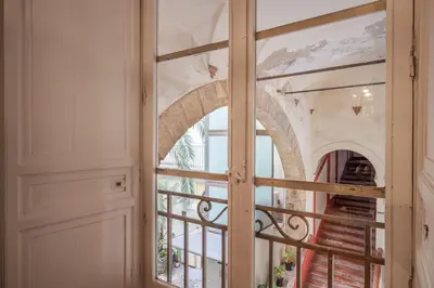 a glass door with a view of an archway at Aurora Apartment by Domus Sicily in Palermo