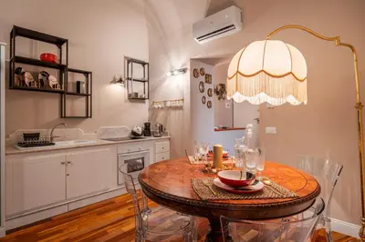 a dining room with a table and a kitchen at Aurora Apartment by Domus Sicily in Palermo