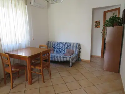 a living room with a table and a couch at Awesome terrace and apartment in the city centre in Palermo