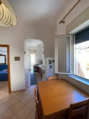 a kitchen and dining room with a wooden table at Awesome terrace and apartment in the city centre in Palermo