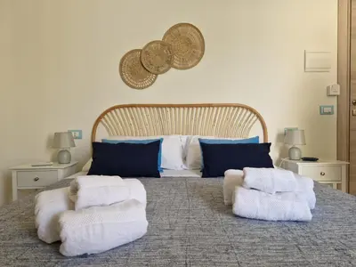 a bedroom with a large bed with towels on it at Posidonia B&B in Terrasini