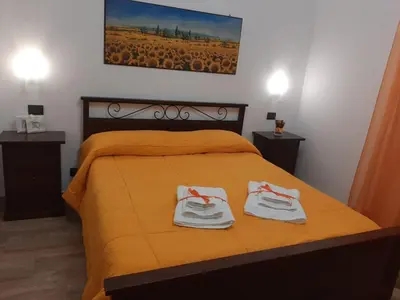 a bedroom with a yellow bed with two towels on it at Casa vacanze Il Girasole in Bagheria