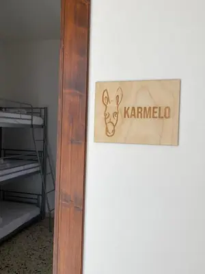 a sign that reads karmacolo hanging on a wall at Il Rifugio della Grotta S.Ninfa in Santa Ninfa