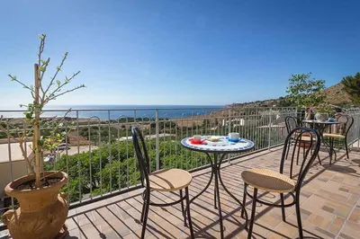 a patio with a table and chairs and the ocean at Verdemare in Macari